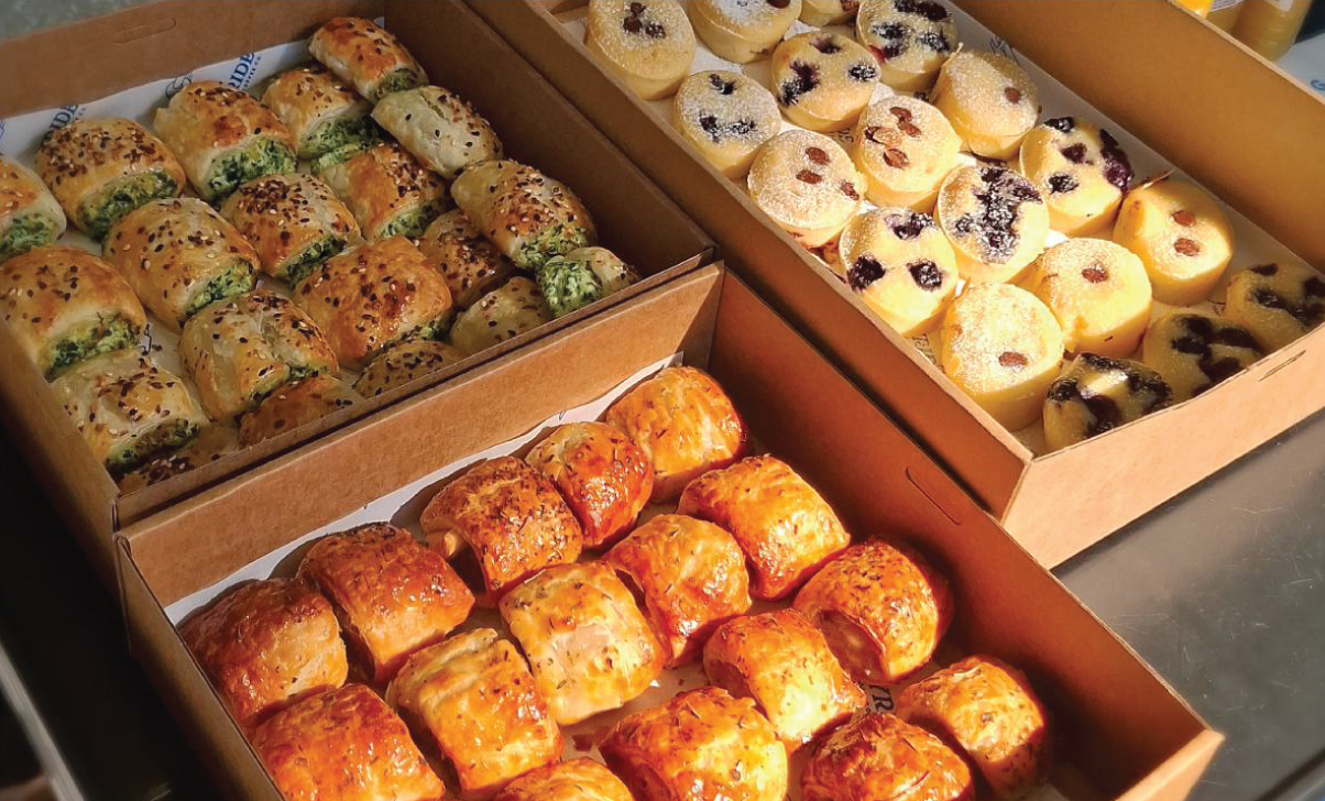Boxes of fresh catering — sausage rolls, pastries and friands